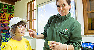 Operatirice dell'Ente Foreste Sardegna che trucca una bambina per la giornata del benessere psicologico a Mont'Arrubiu