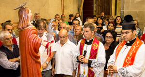 Foto del Parroco di Dolianova e dei fedeli rivolti in preghiera al Patrono San Pantaelo di Dlianova.